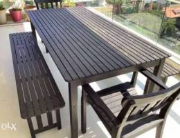 Wooden outdoors table with chairs and benc...